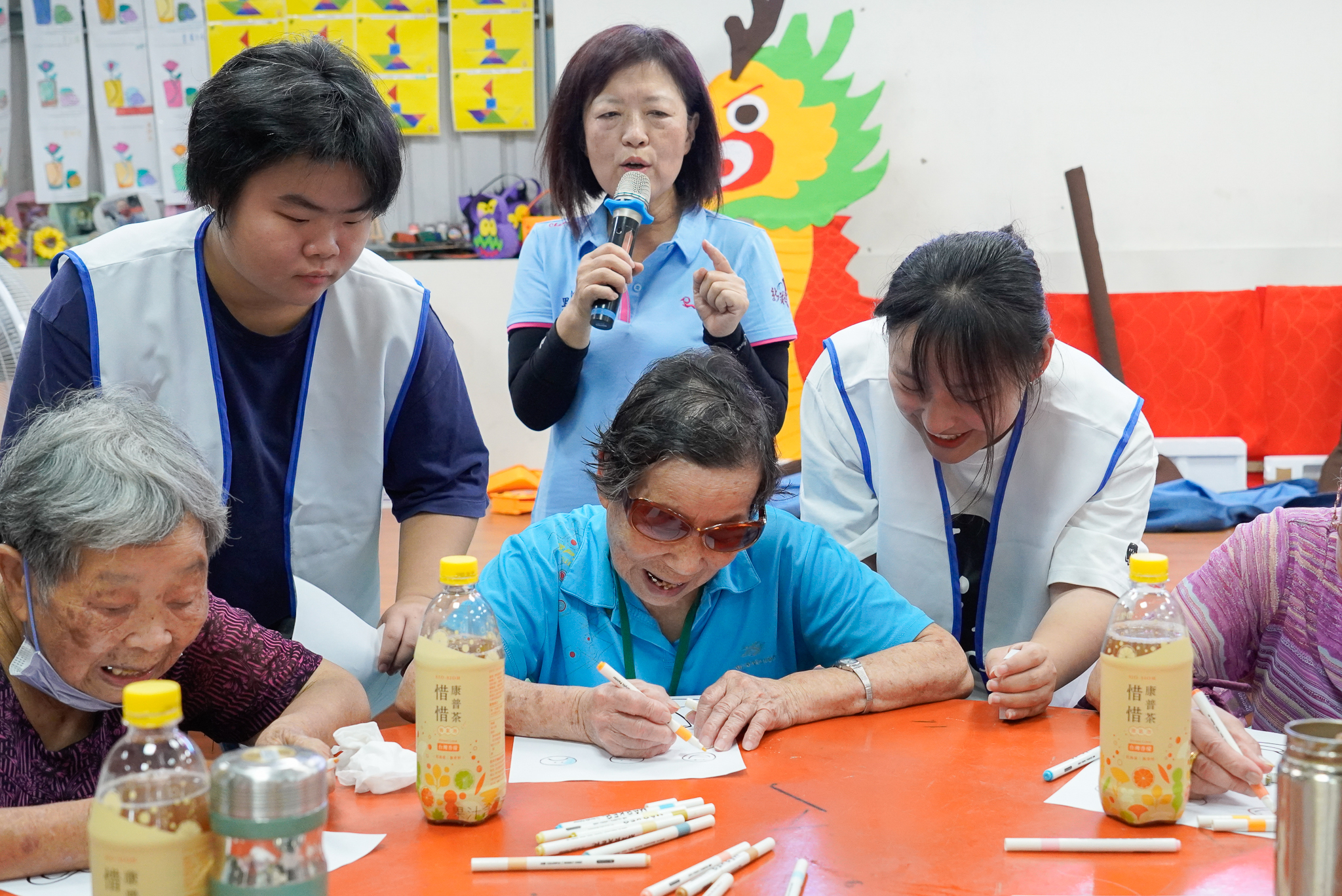少年陪長輩一起彩繪咖啡杯 後中為新莊雙鳳里長潘素娥